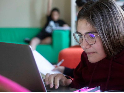 Una alumna treballant a l'ordinador, en una aula