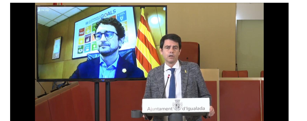 Moment de la roda de premsa, amb l'alcalde d'Igualada, marc Castells, en primer terme, des de l'Ajuntament, i el conseller, en connexió en directe des del seu despatx, a Barcelona.