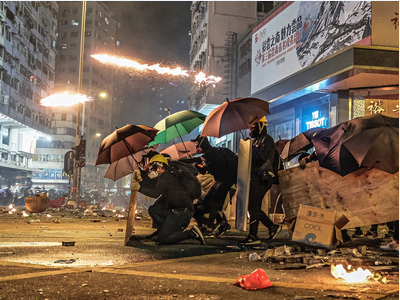 Diversos manifestants es protegeixen amb paraigües i altres objectes durant les protestes a Hong Kong, el 18 de novembre de 2019