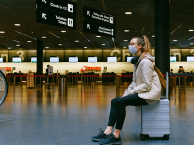 Una dona amb mascareta espera en un aeroport.