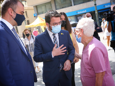 El president Aragonès i l'alcalde de Terrassa saluden una veïna (foto: Jordi Bedmar)