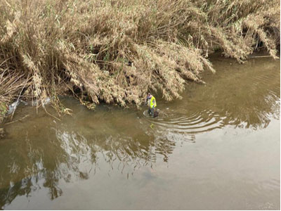 Tècnic retirant peixos morts en un tram del riu Besòs a l'endemà de l'incendi. 