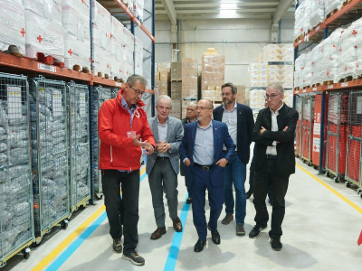 El conseller amb responsables de Creu Roja visita el magatzem