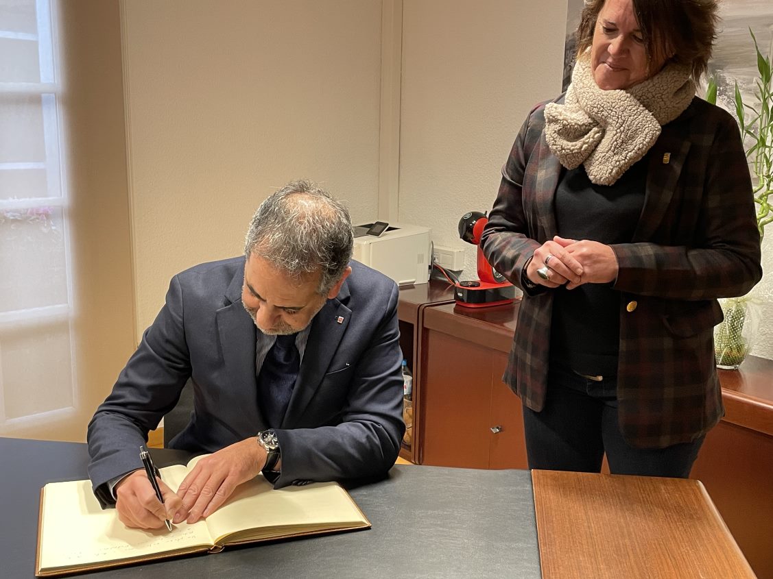 El delegat del Govern de la Generalitat a Barcelona, Joan Borràs, signa el Llibre d'Honor de l'Ajuntament de Santa Susanna i a la seva dreta hi ha l'alcaldessa del municipi, Sònia Viñolas. 