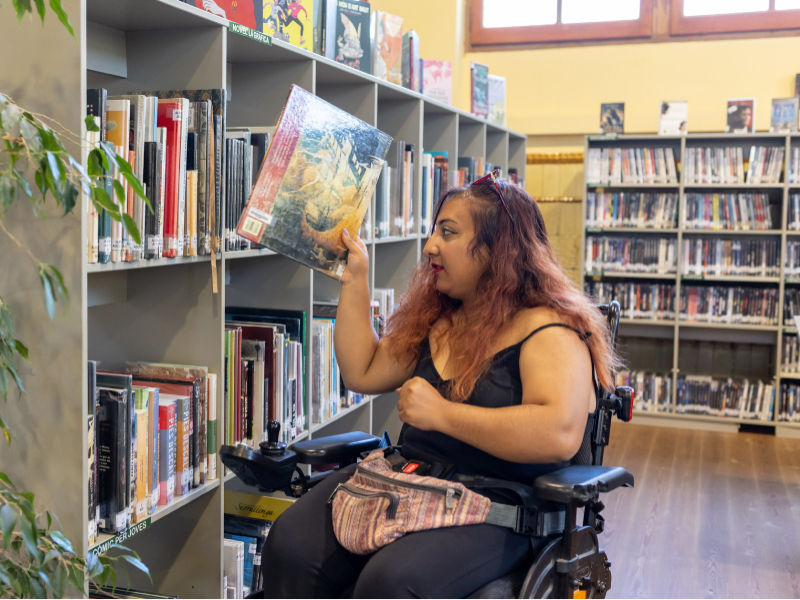 Una noia en cadira de rodes visita una biblioteca