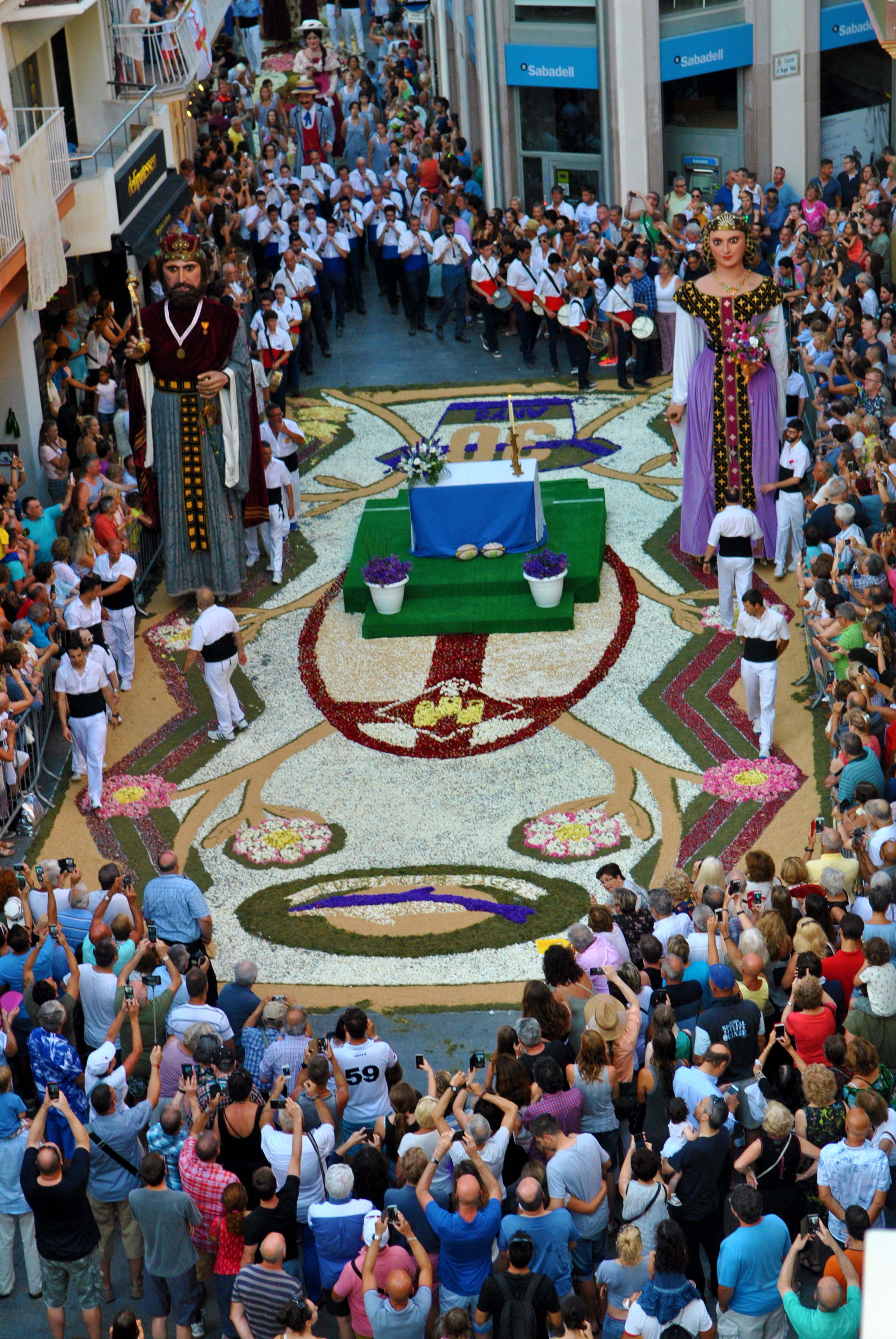 Els gegants centenaris trepitjant la catifa del Cap de la Vila en la Processó de Corpus