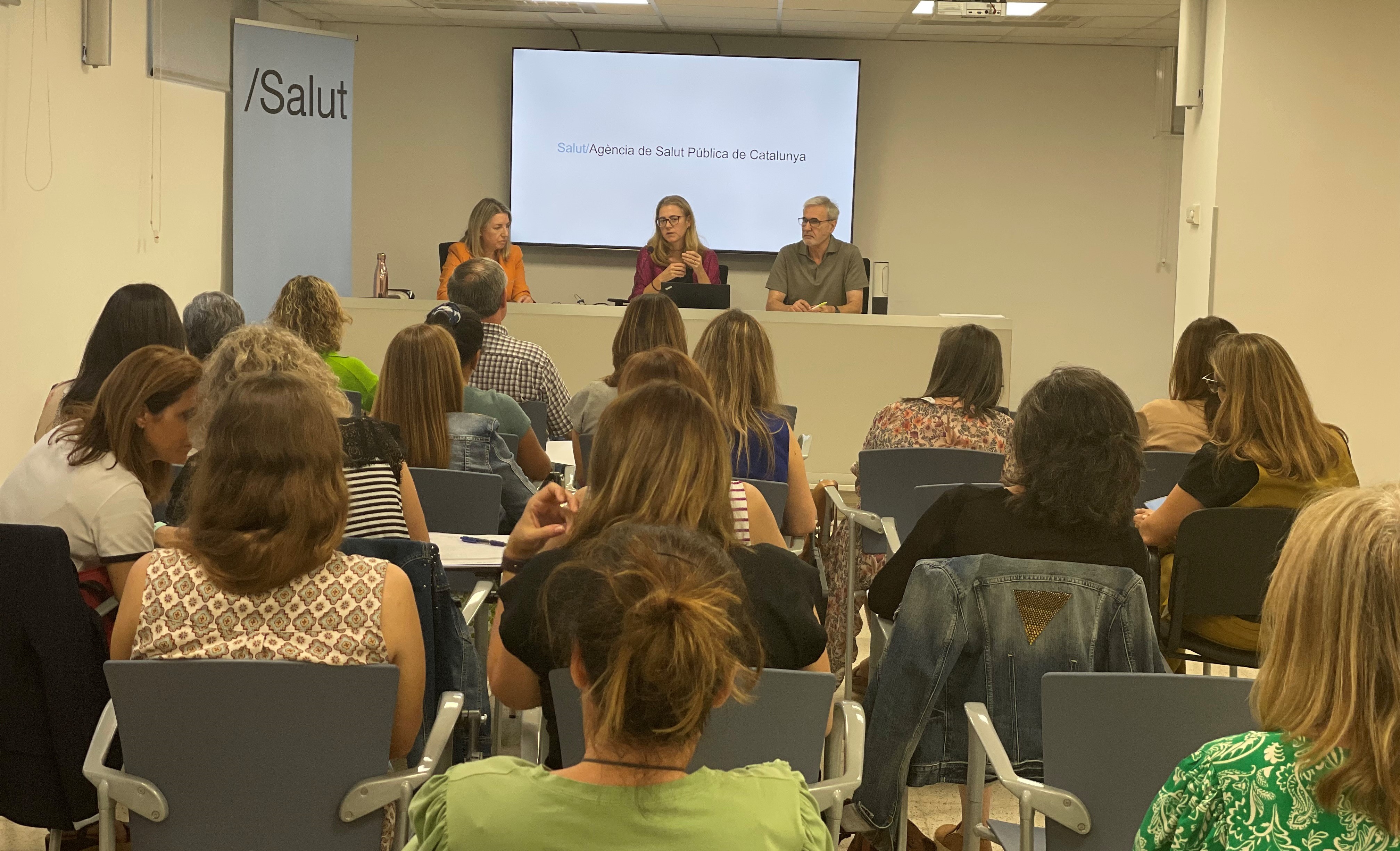 La subdirectora de Salut Pública a les regions sanitàries de Lleida i Alt Pirineu i Aran, Mercè Bieto (al centre) acompanyada de Montse Puiggené i Rafael Panadès, presenta la sessió davant una quarantena d’assistents. 