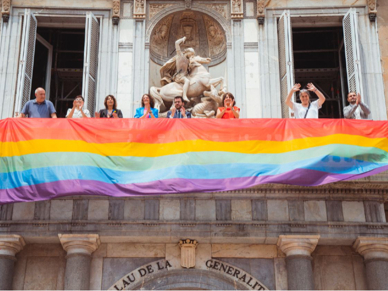 Desplegament de la bandera LGBTI+ a la balconada principal del Palau de la Generalitat (Fotografia: Arnau Carbonell)