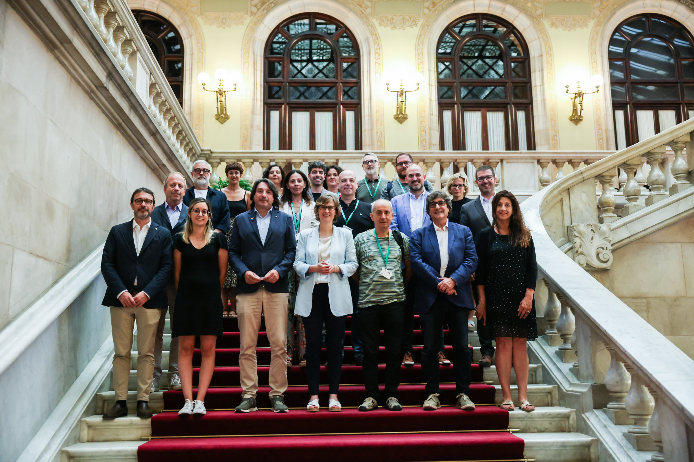 Foto de família de la consellera Serret, acompanyada de l'equip del Departament, amb els grups parlamentaris que han aprovat el pla.