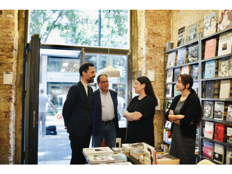 El conseller d'Empresa i Treball, Roger Torrent, i el secretari de Treball, Enric Vinaixa, durant la visita a la llibreria Restory.